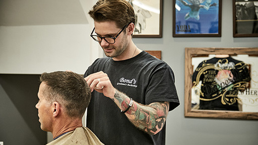 Bond's Barbershop Lymington - Barber cutting hair with scissors