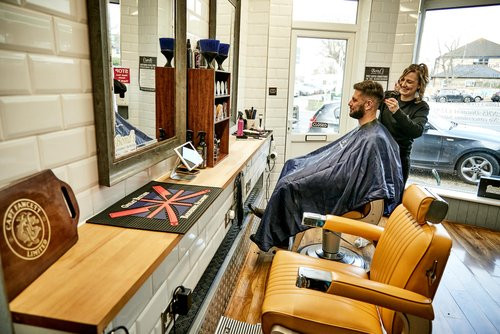 Bond's Barbershop Poole - Barber cutting a customer's hair